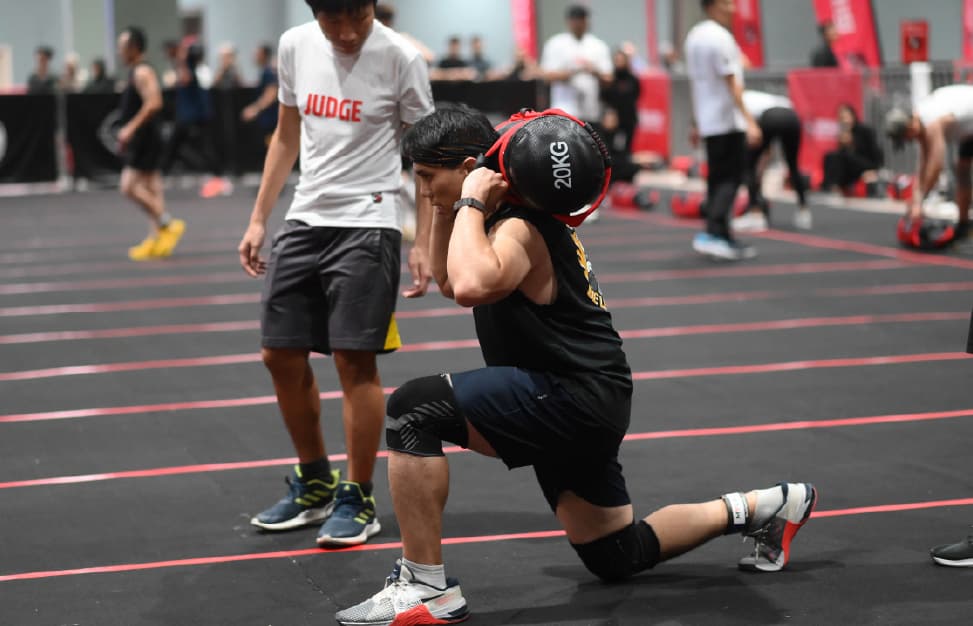 Competitor performing sandbag lunges at Redline Fitness Games